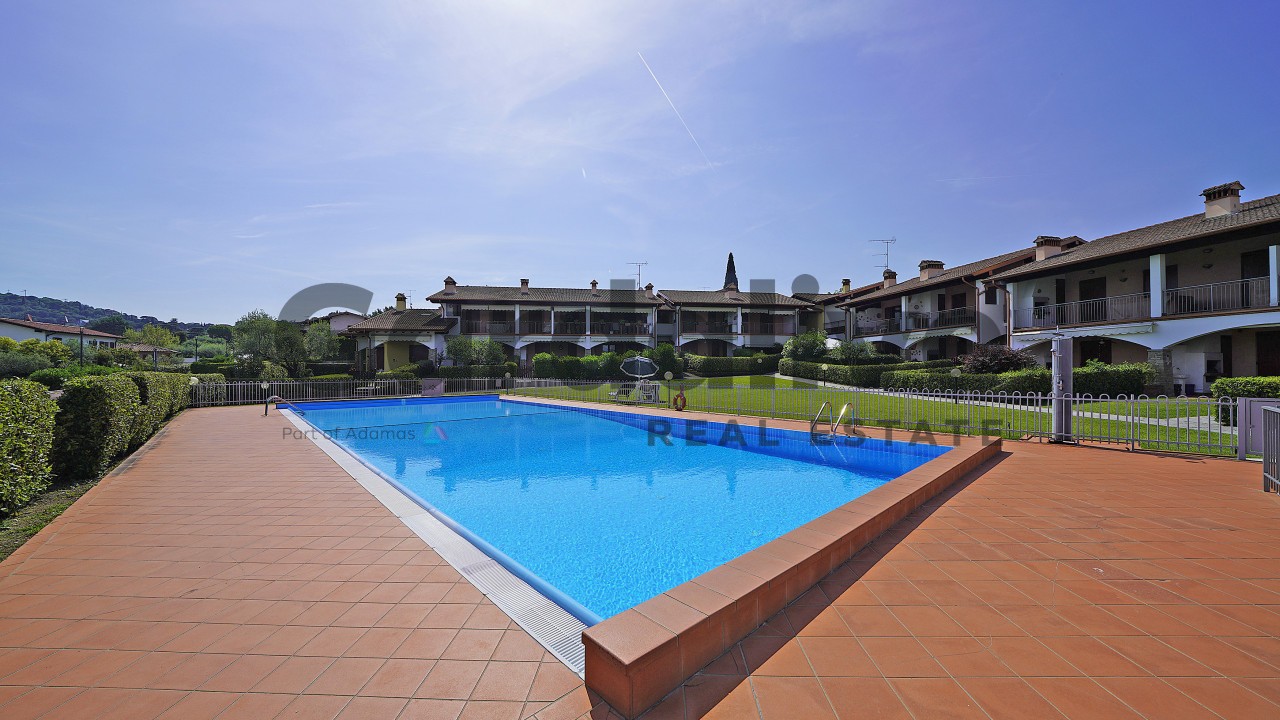 Trilocale di testa con doppi servizi e giardino privato in residence con piscina